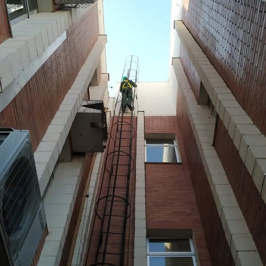Técnico da Detecta em escada externa de um prédio