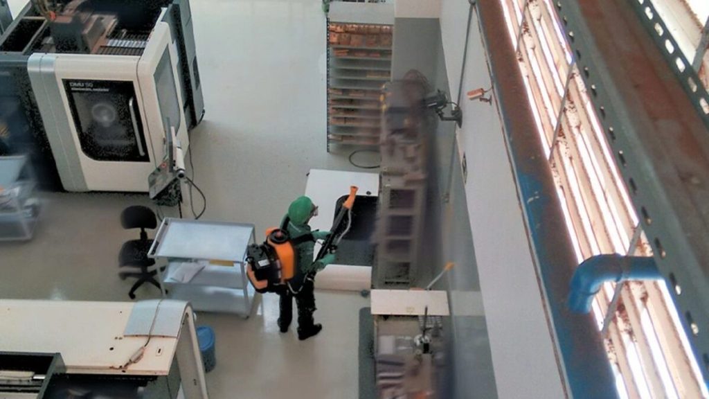 Técnico realizando aplicação profissional de controle de pragas.