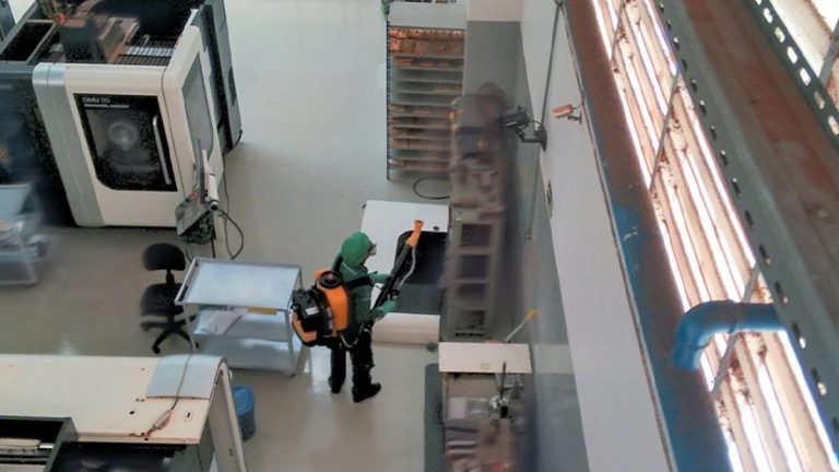 Técnico realizando aplicação profissional de controle de pragas.